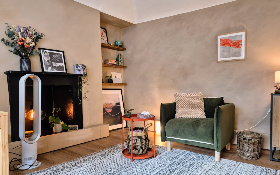 a therapy room showing the client's chair, and decorative details including prints, dried flowers and a shelf with books